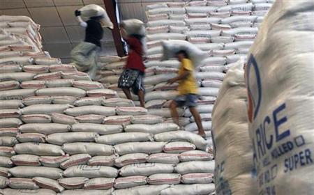 Workers carry sacks of rice in the National Food Authority warehouse in Taguig city